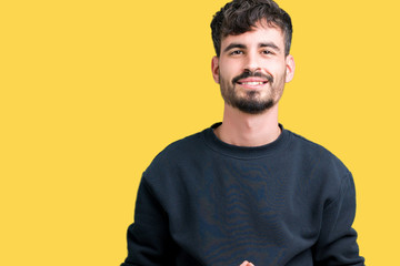 Obraz premium Young handsome man over isolated background Hands together and fingers crossed smiling relaxed and cheerful. Success and optimistic