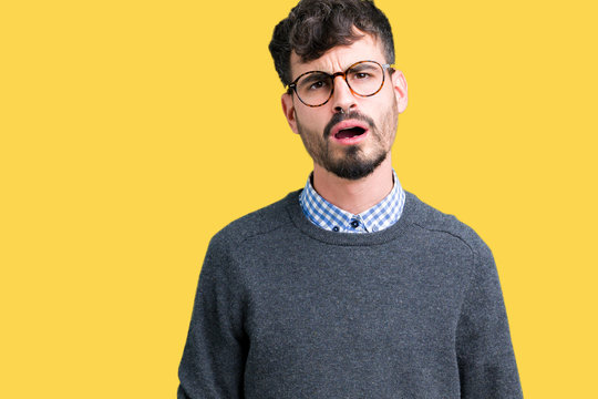 Young handsome smart man wearing glasses over isolated background In shock face, looking skeptical and sarcastic, surprised with open mouth