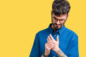 Young handsome man wearing glasses over isolated background Suffering pain on hands and fingers,...