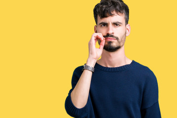 Young handsome man over isolated background mouth and lips shut as zip with fingers. Secret and...