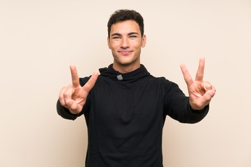 Handsome man over isolated background smiling and showing victory sign