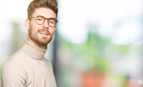 Young handsome business man wearing glasses Inviting to enter smiling natural with open hand