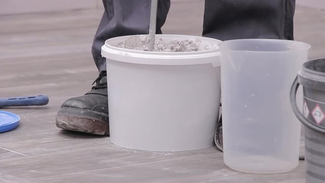 Mixing grout in white bucket