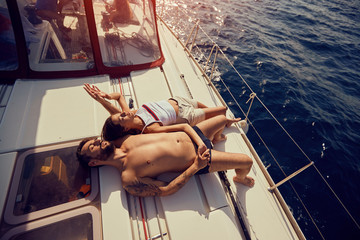 couple on boat sunbathing and enjoying on summer day