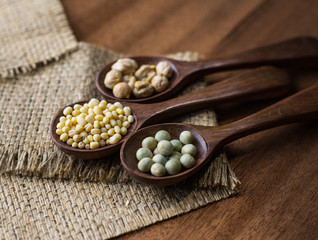 collection set of urad dal, beans, green peas, lentils, rice in wooden spoons.