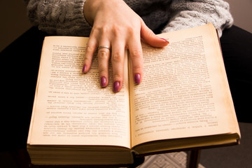 Naklejka premium hand of a woman on old book
