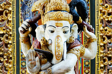 statue of ganesh …god of prosperity and success with carved door in balinese temple 