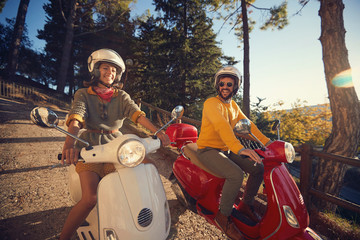 Happy couple in love on scooter driving together on journey..