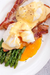 Benedict eggs with hollandaise sauce and bacon