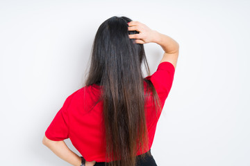 Beautiful brunette woman wearing red t-shirt over isolated background Backwards thinking about doubt with hand on head