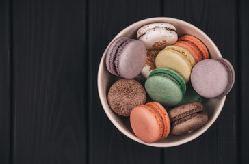 Top view of set macaron on black table background. Traditional french dessert. Delicious food