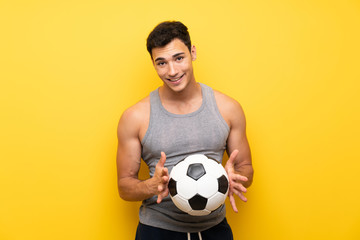 Handsome sport man over isolated background with a soccer ball