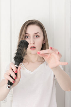 Woman in her bathroom with a comb for the hair, vertical
