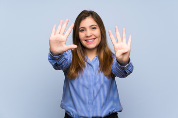 Young girl over isolated blue wall counting nine with fingers