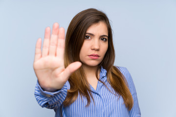 Young girl with striped shirt making stop gesture with her hand