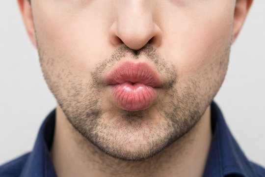Beautiful bearded man sending air kiss, closeup