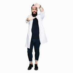 Fototapeta premium Doctor therapist man with long hair and bear wearing white coat smiling making frame with hands and fingers with happy face. Creativity and photography concept.