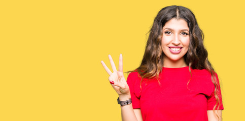 Young beautiful woman wearing casual t-shirt showing and pointing up with fingers number three while smiling confident and happy.