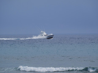 White yacht sailing at high speed in the Atlantic Ocean.