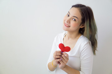Asian woman holding a red heart in her hands.