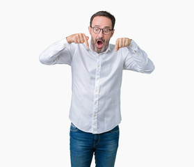 Handsome middle age elegant senior business man wearing glasses over isolated background Pointing down with fingers showing advertisement, surprised face and open mouth