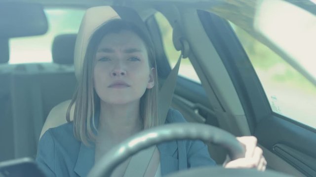 Serious young woman driver use phone while driving a car sunset sunlight communication adult cellphone female automobile dangerous connection road sitting smartphone texting slow motion