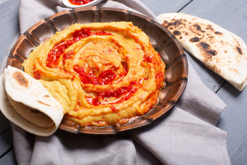 Hummus on a plate. Chickpea dish prepared with harissa sauce