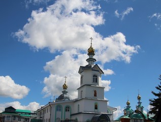 Fototapeta na wymiar white clouds above the church under the blue sky in the city of Kanash, Chuvashia