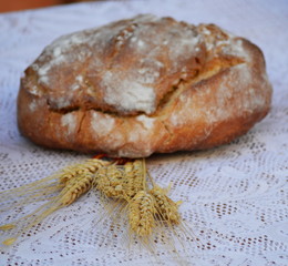 Some bread and a bunch of yellow wheat spikes 