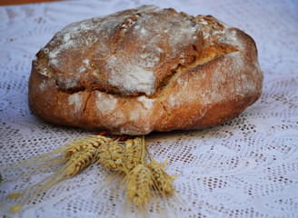 Some bread and a bunch of yellow wheat spikes 