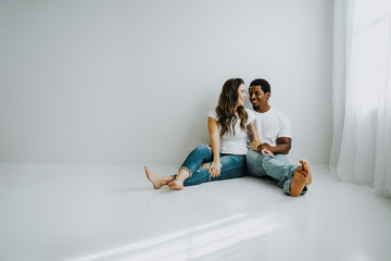 Happy Biracial Couple in Modern White Room