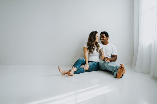 Happy Biracial Couple in Modern White Room