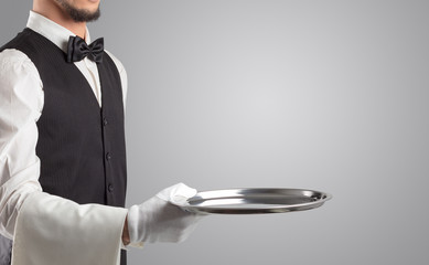 Waiter serving with white gloves and steel tray in an empty space
