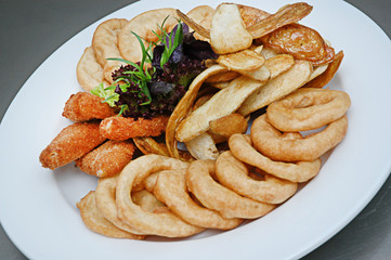 Chicken nuggets, french fries and sauce. Fried nuggets and potato with basil oak lettuce