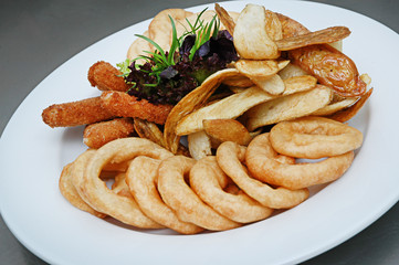 Chicken nuggets, french fries and sauce. Fried nuggets and potato with basil oak lettuce