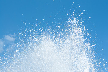 Cool and fresh water splashes on the clear blue sky background.