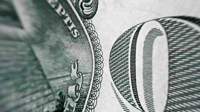 Close-up view of turning deformed dollar bill. One dollar is rotates, macro view.