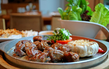 Closeup sizzling beef steak with blurry fresh vegetable in background