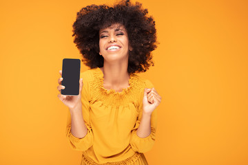 Excited afro girl with mobile phone.