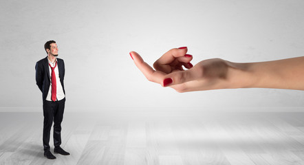Businessman with kisses on his face in an empty space where a big hand baiting him
