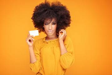 Afro girl holding credit card in hand.