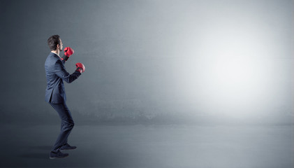 Fototapeta premium Businessman fighting with boxing gloves in an empty space 