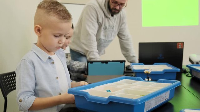 Smart little boys try to figure out how to engineer automatic plastic cars slow motion