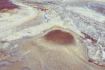 Aerial view of surrealistic industrial place. Dry surface. Desertic landscape. Human impact on the environment. View from above. Abstract industrial background.