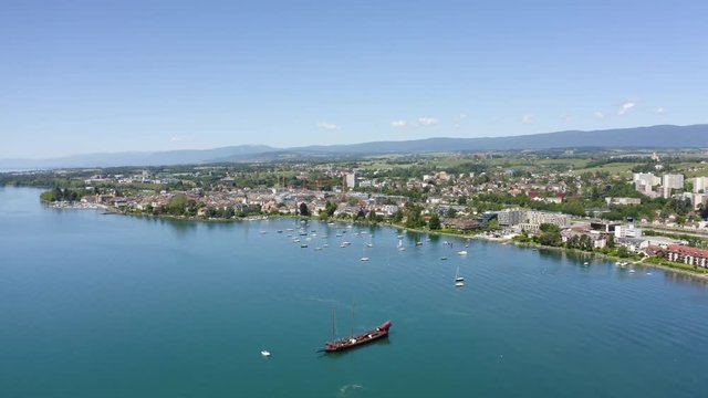 Aerial panning of Morges agglomeration with Galley anchored in foreground