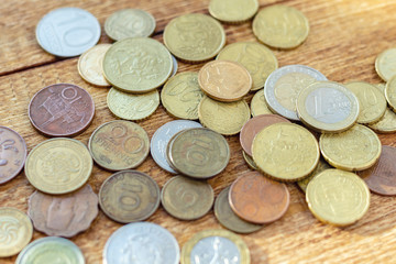 coins old rusty brass euro Seychelles Bulgaria China Germany pile pack heap stack on a wooden background finance economy investment savings concept mock up selective focus close up