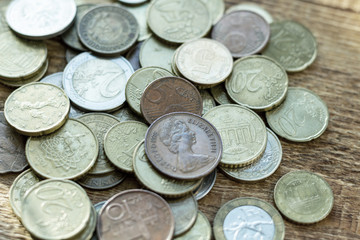 coins old rusty brass euro Seychelles Bulgaria China Germany pile pack heap stack on a wooden background finance economy investment savings concept mock up selective focus close up