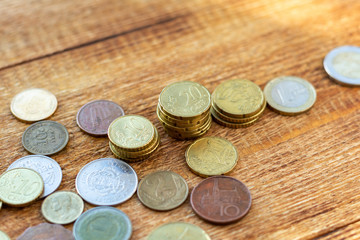 coins old rusty brass euro Seychelles Bulgaria China Germany pile pack heap stack on a wooden background finance economy investment savings concept mock up selective focus close up