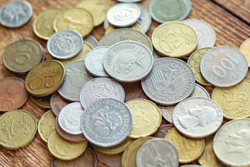 coins old rusty brass euro Seychelles Bulgaria China Germany pile pack heap stack on a wooden background finance economy investment savings concept mock up selective focus close up