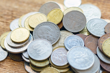 coins old rusty brass euro Seychelles Bulgaria China Germany pile pack heap stack on a wooden background finance economy investment savings concept mock up selective focus close up
